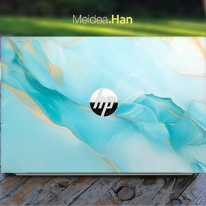 Pode incluir: Um computador portátil com um design de mármore azul e dourado. O logotipo da HP é visível no laptop.
