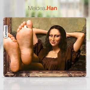 May include: A laptop skin featuring a painting of a woman with long brown hair, wearing a brown dress, and resting her head on her hands. The woman's feet are visible in the bottom of the frame. The skin has a gold frame and the text "Meidea.Han" is printed at the top. The text "Lenovo" is printed on the left side of the skin.