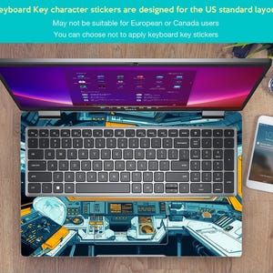 May include: A silver laptop with a keyboard and a colorful design on the lid. The design features a futuristic cockpit with blue, yellow, and white accents. The laptop is on a wooden surface with a smartphone and a watch.