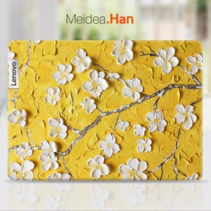 May include: A yellow laptop skin with a white floral design. The skin has the word "Lenovo" printed on the left side.