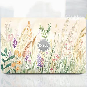 May include: A laptop skin with a watercolour design of wildflowers and grasses in yellow, purple, pink, and green. The Dell logo is in the centre. The background is a soft, creamy colour.