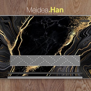 Puede incluir: Port&aacute;til negro con una piel de dise&ntilde;o de m&aacute;rmol dorado y negro. La piel tiene un patr&oacute;n de remolino con detalles dorados y un sutil efecto de brillo.