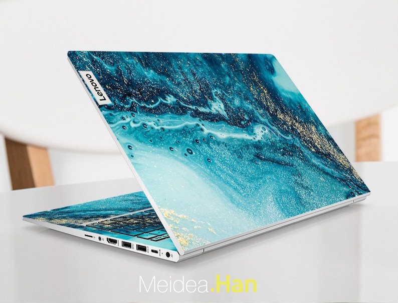 Op de afbeelding: Een laptop met een abstract ontwerp in blauw en goud op de deksel. Het Lenovo-logo is zichtbaar op de deksel.
