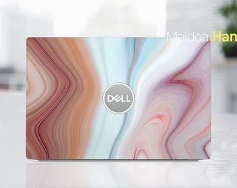 May include: A laptop computer with a marble-patterned design in shades of pink, white, and brown. The Dell logo is visible on the lid.
