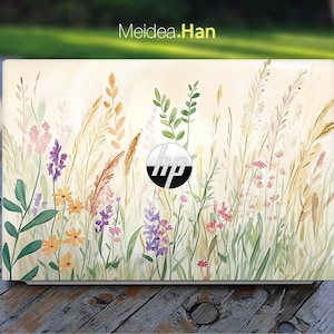 Puede incluir: Un ordenador portátil con un diseño floral en la tapa. El diseño presenta una variedad de flores y hierbas en tonos de rosa, amarillo, verde y blanco. El logotipo de HP es visible en el centro de la tapa.