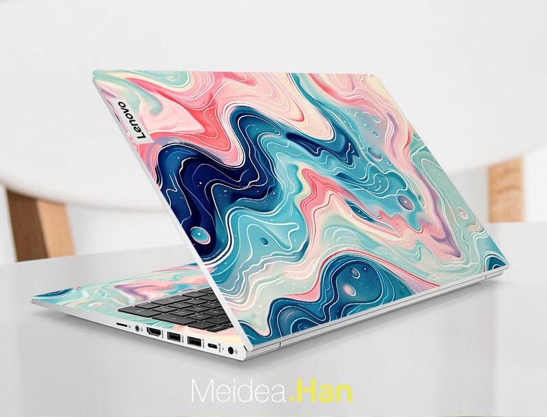 Op de afbeelding: Een zilveren laptop met een blauw, roze en wit marmerpatroon op de deksel. Het Lenovo-logo is zichtbaar op de deksel.