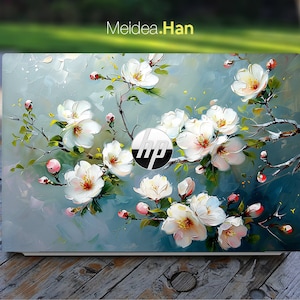 May include: A laptop skin with a floral design featuring white flowers and green leaves on a blue background. The HP logo is visible in the center of the skin.