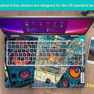May include: Laptop with a keyboard overlay featuring a colourful, artistic design. The keyboard keys are covered with stickers. The laptop is open, displaying a screen with a purple and pink gradient. A smartphone and watch are visible.
