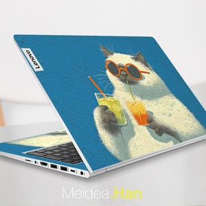 May include: A Lenovo laptop with a blue textured design featuring a cartoon cat wearing sunglasses and drinking from two colourful beverages. The cat is white with black accents. The laptop is open, displaying the keyboard.