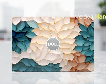 May include: A laptop with a floral design on the lid. The design features white, beige, and teal paper-like flowers. The Dell logo is in the centre of the lid.