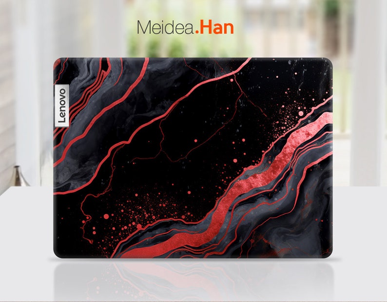 K&ouml;nnte beinhalten: Lenovo Laptop-H&uuml;lle mit einem schwarzen und roten Marmordesign. Die H&uuml;lle hat eine gl&auml;nzende Oberfl&auml;che mit flie&szlig;enden roten Adern und Sprenkeln auf einem schwarzen und grauen Hintergrund. Das Lenovo-Logo ist sichtbar.