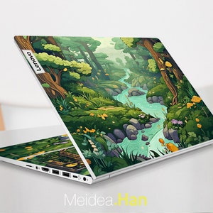 May include: A white laptop with a colorful cartoon forest scene on the lid. The scene features a winding river, green trees, and yellow mushrooms. The laptop has the Lenovo logo on the lid.