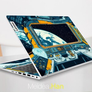 May include: A laptop computer with a blue and yellow space-themed design. The design features a view of Earth from space, with a window looking out at the planet. The laptop has a keyboard and a touchpad.