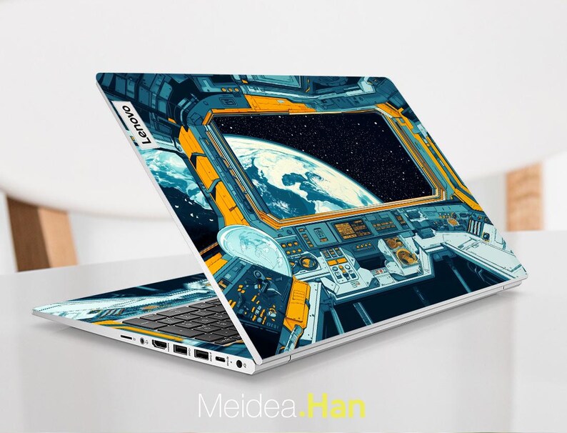 May include: A laptop computer with a blue and yellow space-themed design. The design features a view of Earth from space, with a window looking out at the planet. The laptop has a keyboard and a touchpad.