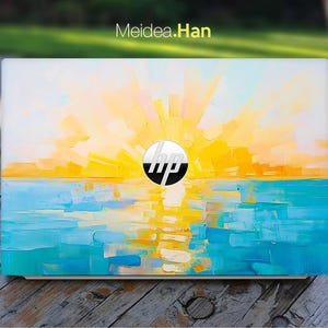 May include: A white laptop with a sunset and ocean scene painted on the lid. The scene features a yellow and orange sunset over a blue ocean with white clouds. The HP logo is in the center of the lid.