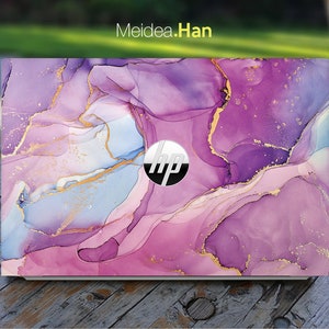 Könnte beinhalten: Eine Laptop-Haut mit einem abstrakten Marmormuster in Lila, Rosa und Blau mit goldenen Akzenten. Die Haut hat das HP-Logo in der Mitte.