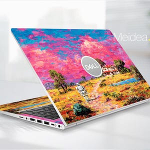 May include: A Dell laptop with a vibrant, colorful skin featuring an impressionistic landscape painting. The design includes a house, trees, a figure, and a bright sky with pink, blue, and yellow hues. The laptop is open, displaying the keyboard and screen.