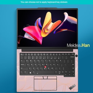 May include: A pink laptop with a black keyboard and a colorful abstract design on the screen. The keyboard has a US standard layout. The laptop's surface has a gold floral pattern. The text "Meidea.Han" is visible on the screen.