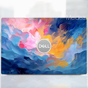 Puede incluir: Un ordenador portátil con un diseño abstracto colorido en la tapa. El diseño presenta tonos de azul, rosa, amarillo y naranja. El logotipo de Dell es visible en el centro de la tapa.