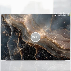 May include: A laptop with a decorative skin featuring a swirling design in shades of black, gray, and gold. The Dell logo is centered on the laptop. The text "Meidea Han" is in the upper right corner.