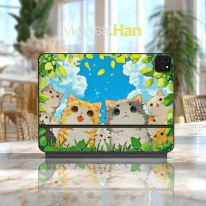 May include: A black tablet case with a cartoon illustration of cats in various colours, including orange, grey, and white, set against a blue sky. The case has the text "Meidea.Han" at the top.
