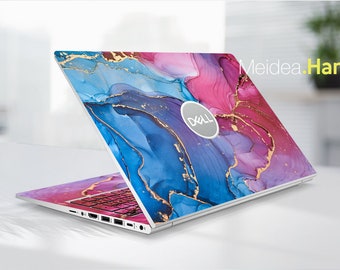 May include: A laptop computer with a colourful abstract design on the lid. The design features shades of blue, pink, and gold, resembling a marble or watercolour effect. The Dell logo is visible on the lid.