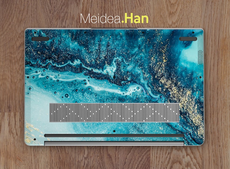 Op de afbeelding: Een laptop met een teal en gouden marmerpatroon. De laptop heeft een zilveren afwerking en een zwarte ventilatieopening aan de onderkant.