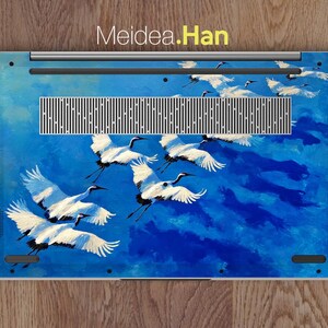 May include: Laptop skin featuring a vibrant blue sky with white cranes in flight. The design includes the text "Meidea.Han" at the top. The cranes are painted with detailed wings and black accents, creating a dynamic and artistic aesthetic.