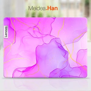Op de afbeelding: Een roze en paarse laptop-huid met een gouden abstract ontwerp. De huid heeft het woord "Lenovo" aan de linkerkant.