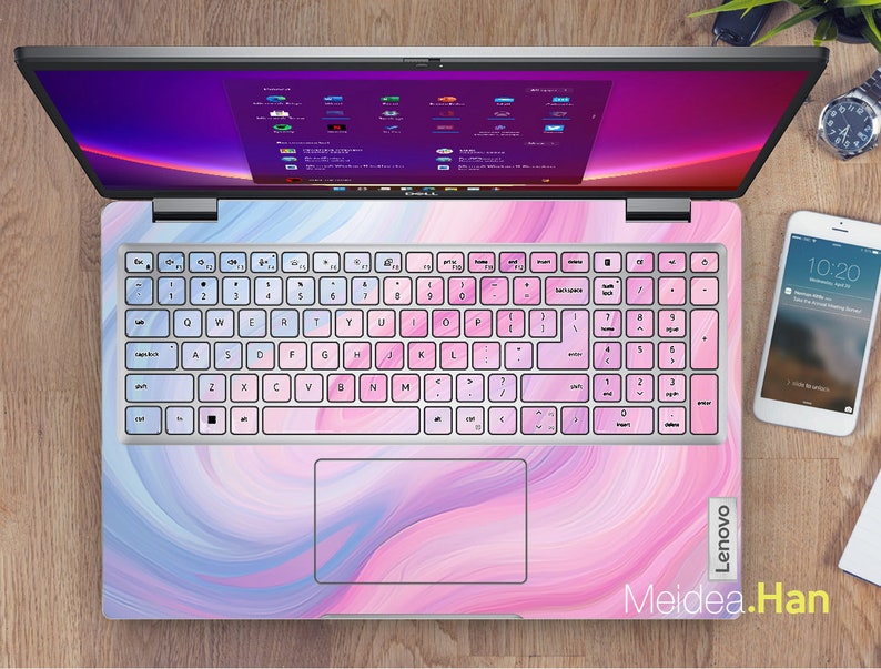 May include: A pink and blue laptop with a swirl design on the lid and a white keyboard. The laptop is open and the screen is showing a desktop with several icons. The text "Lenovo" is visible on the right side of the laptop. The text "Meidea.Han" is visible on the bottom right of the laptop.
