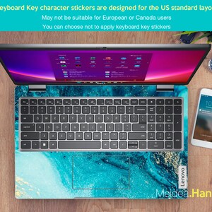 Op de afbeelding: Een laptop met een blauw en gouden marmerontwerp op de deksel. Het toetsenbord heeft een Amerikaanse standaardindeling en de tekst "Keyboard Key character stickers are designed for the US standard layout May not be suitable for European or Canada users You can choose not to apply keyboard key stickers" wordt boven het toetsenbord weergegeven.