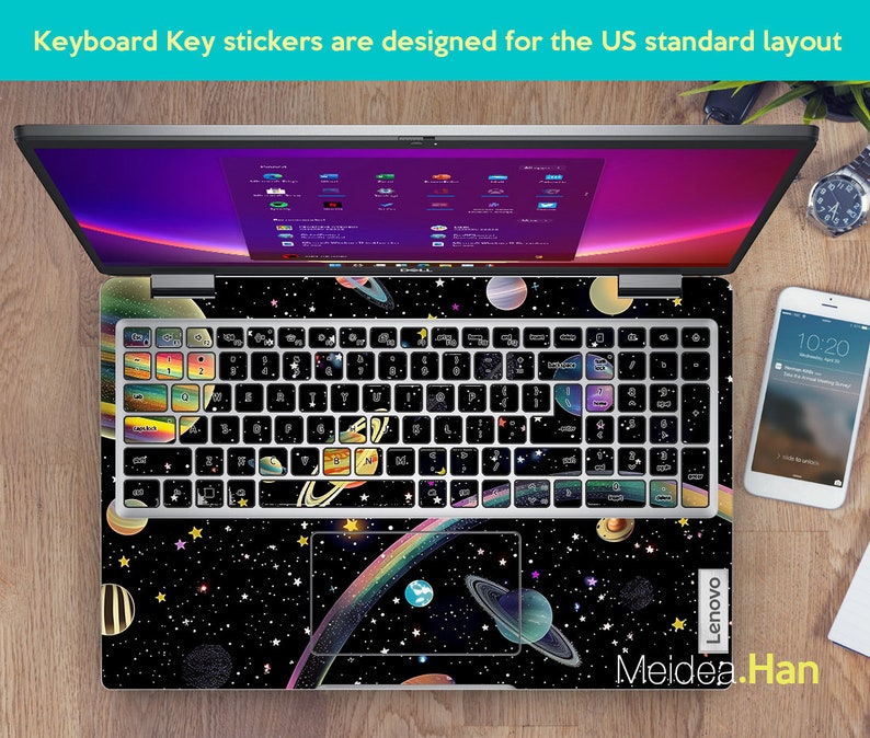May include: A laptop computer with a black and white space-themed keyboard sticker set. The sticker set features planets, stars, and a rainbow. The laptop is a Lenovo.