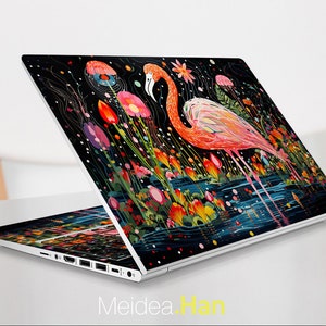 Könnte beinhalten: Ein silberner Laptop mit einem schwarzen Bildschirm, der eine farbenfrohe Illustration eines rosafarbenen Flamingos zeigt, der in einem Teich mit Blumen steht. Die Illustration befindet sich auf einem schwarzen Hintergrund mit weißen Punkten.