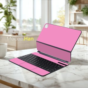 May include: A pink tablet keyboard case with a black keyboard and trackpad. The case is open, revealing the keyboard and a portion of the tablet screen. The text "Meidea.Han" is visible on the left side of the image. The case is on a marble surface.