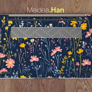 May include: A laptop skin with a floral pattern. The design features pink and yellow flowers on a dark blue background.
