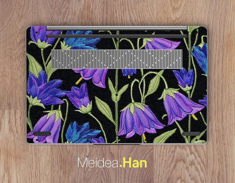 May include: Laptop skin featuring a floral design with purple and blue bellflowers on a black background. The flowers have green stems and leaves. The text "Meidea.Han" is at the bottom.