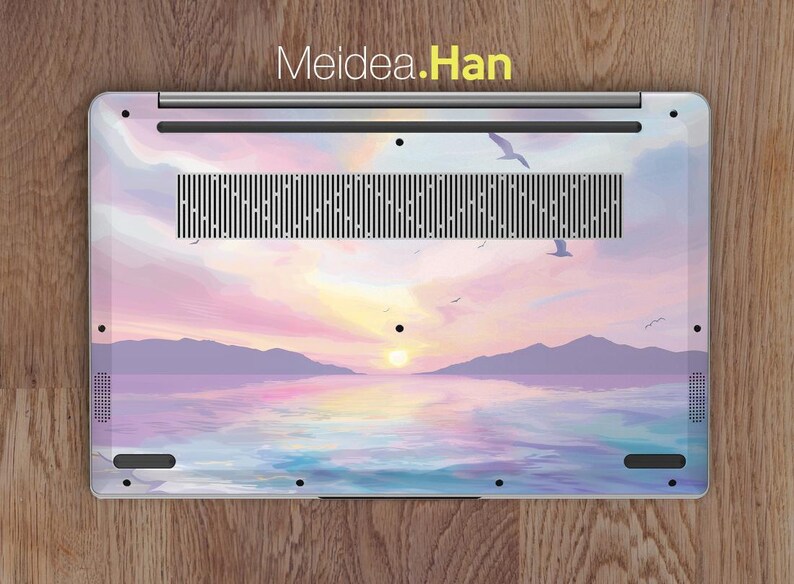 Pu&ograve; includere: Una skin per laptop con un tramonto pastello su uno specchio d'acqua con uccelli in volo. La skin ha un logo Meidea.Han.