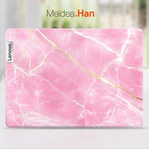 May include: Pink laptop skin with a marble pattern and gold veins. The skin has the word "Lenovo" printed on the left side.