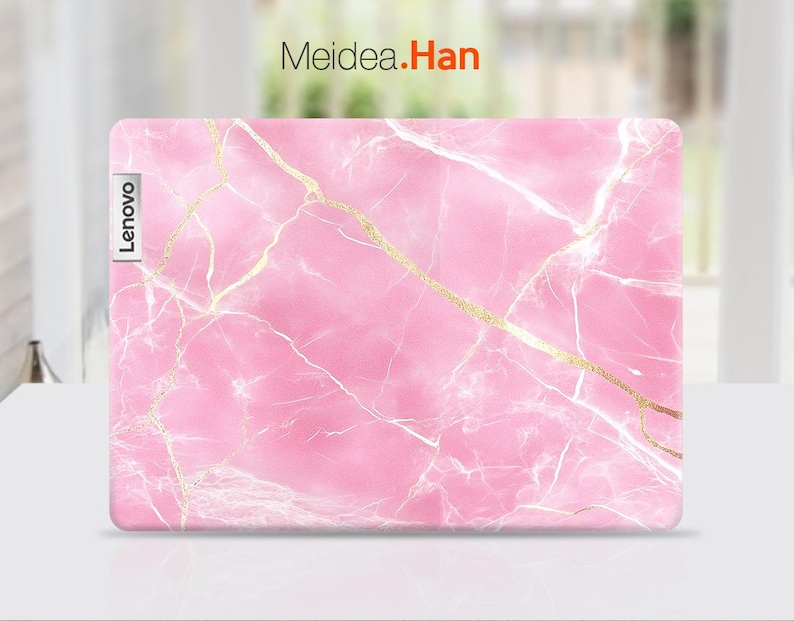 May include: Pink laptop skin with a marble pattern and gold veins. The skin has the word "Lenovo" printed on the left side.