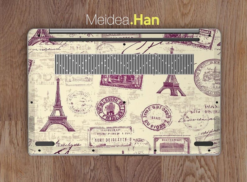 May include: A laptop skin with a vintage Parisian theme. The design features a cream background with purple stamps and illustrations of the Eiffel Tower, Parisian street signs, and other Parisian landmarks.