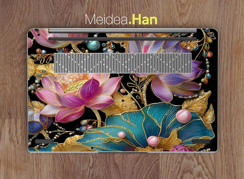 May include: Laptop skin featuring a floral design with pink, purple, and teal lotus flowers, gold leaves, and pearl accents on a black background. The text "Meidea.Han" is at the top.