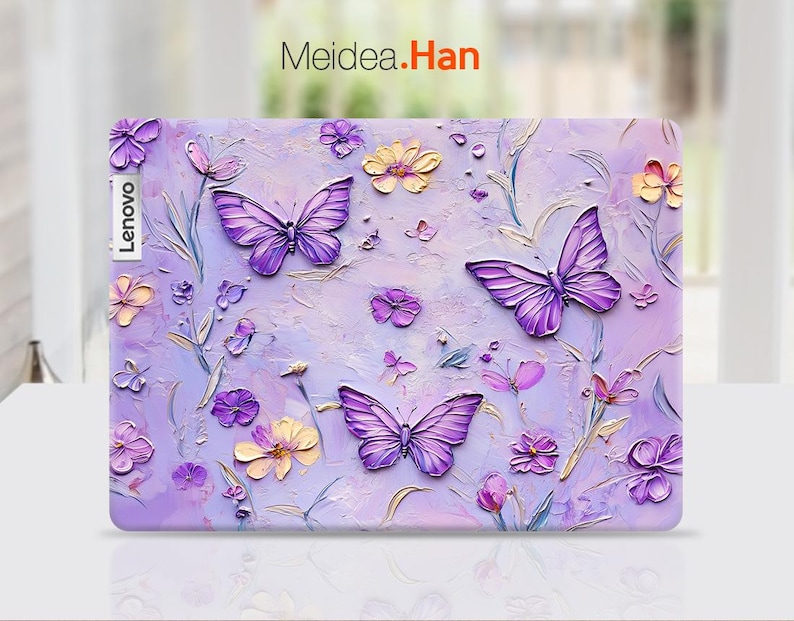 May include: Purple laptop skin with a floral design featuring butterflies and flowers. The text "Meidea.Han" is printed on the skin.