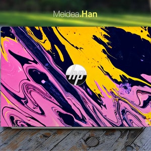 May include: A laptop computer with a colourful abstract design on the lid. The design features swirls of pink, yellow, and blue paint. The HP logo is visible in the centre of the lid.