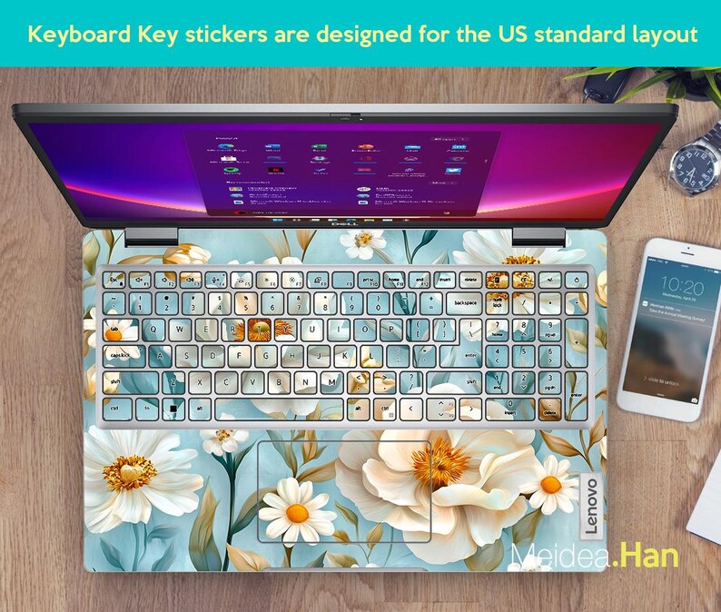 Puede incluir: Un ordenador port&aacute;til con una pegatina de teclado floral. La pegatina presenta flores blancas y amarillas sobre un fondo azul. La pantalla del port&aacute;til muestra un escritorio con iconos. El texto "Keyboard Key stickers are designed for the US standard layout" es visible en la parte superior de la imagen.
