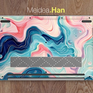 Op de afbeelding: Een laptop met een kleurrijk abstract ontwerp op de achterkant. Het ontwerp bevat swirls van blauw, roze en wit, met een vleugje geel. De laptop heeft een zilveren afwerking en een zwart luidsprekerrooster.