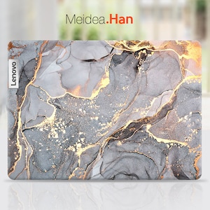May include: A gray and gold marble laptop skin with the word "Lenovo" printed on the left side.