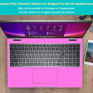 May include: A pink laptop computer with a silver keyboard and a touchpad. The laptop is on a wooden surface. The text on the screen reads "Keyboard Key character stickers are designed for the US standard layout. May not be suitable for European or Canada users. You can choose not to apply keyboard key stickers."