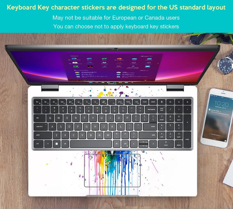 Pu&ograve; includere: Un laptop con una cover per tastiera bianca con disegni di schizzi di vernice colorati. La tastiera ha tasti neri e lo schermo mostra un'interfaccia viola e rosa. Sono visibili anche uno smartphone e un orologio.