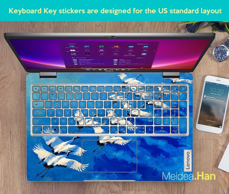 May include: Laptop keyboard with blue key stickers featuring white cranes against a blue sky design. The keyboard keys are light blue. The text "Keyboard Key stickers are designed for the US standard layout" is at the top. The brand name "Lenovo" is visible.