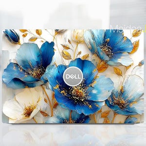 May include: A laptop skin featuring a floral design with large, stylized blue and white flowers with gold accents. The Dell logo is centered on the skin. The design is set against a white background.